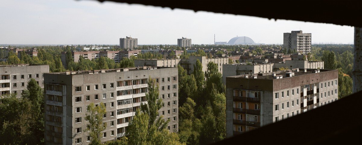 View of Pripyat from an abandoned building, with the New Arch containing Chernobyl’s Reactor 4 in the background.