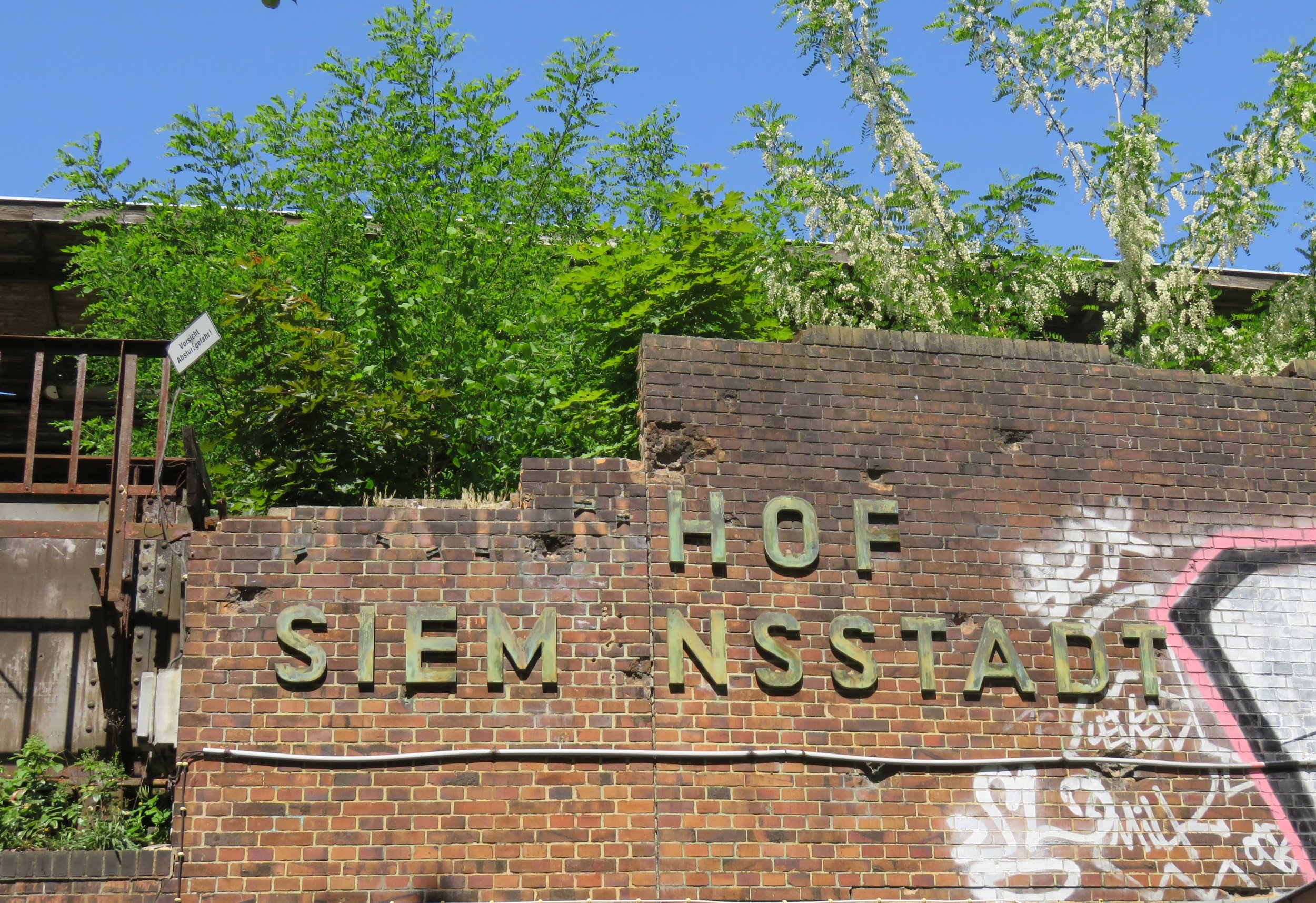 The decaying sign on the west-facing wall of the former Bahnhof Siemenssdadt.