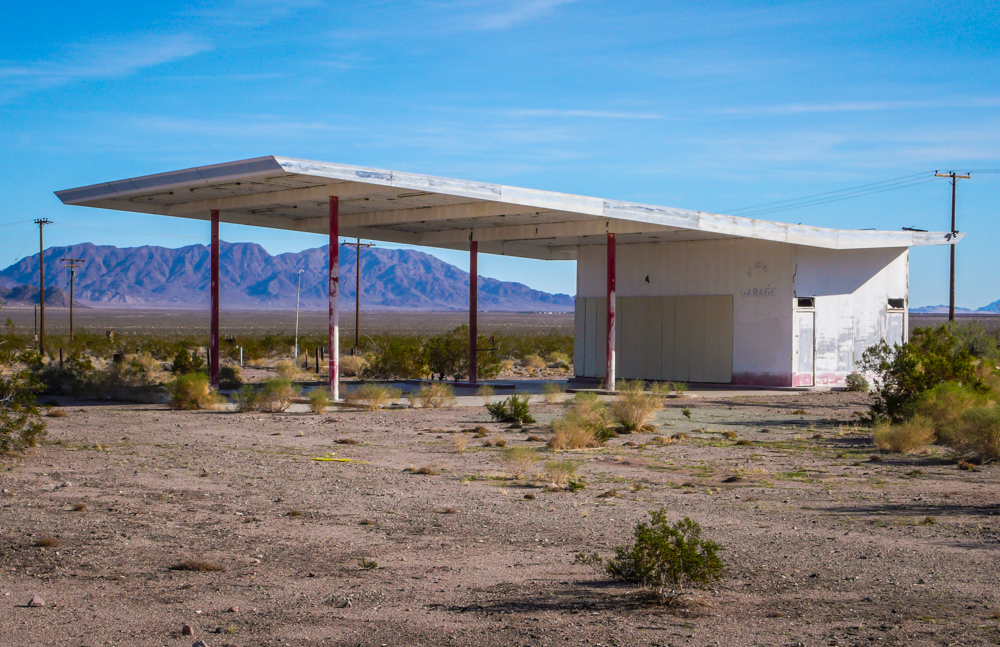 The unmistakable shape of a gas station. The faded words on the building read ‘Official Garage’.